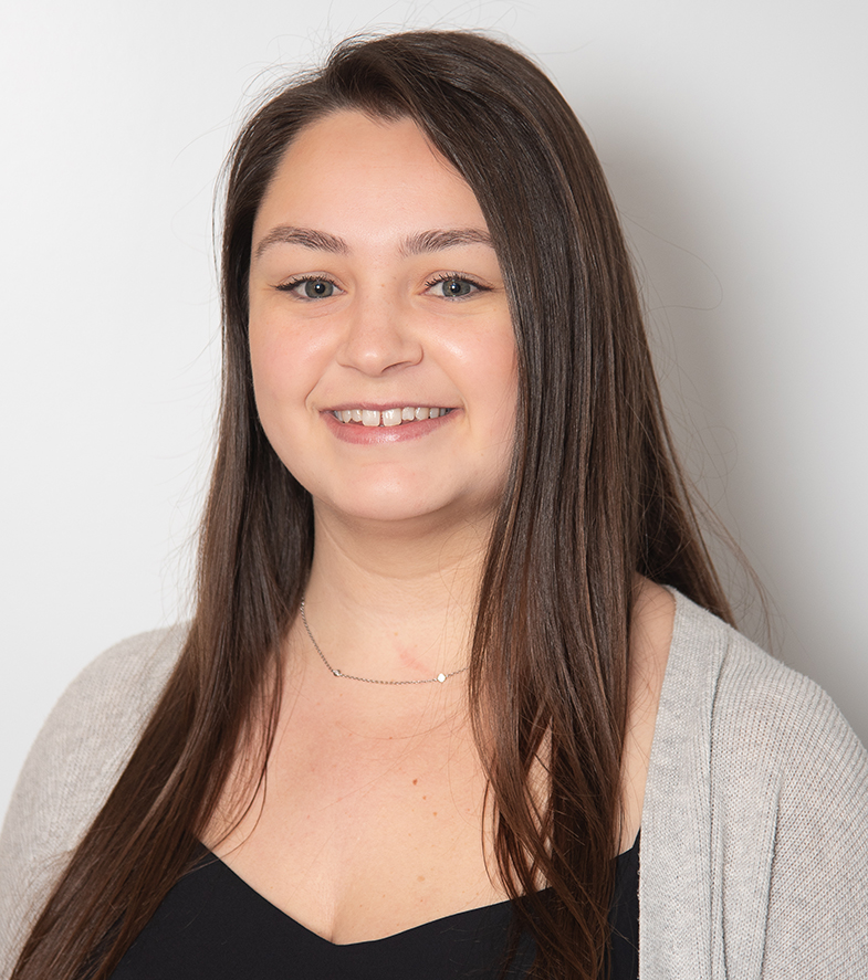 Young woman smiling at camera in professional headshot for dental office.