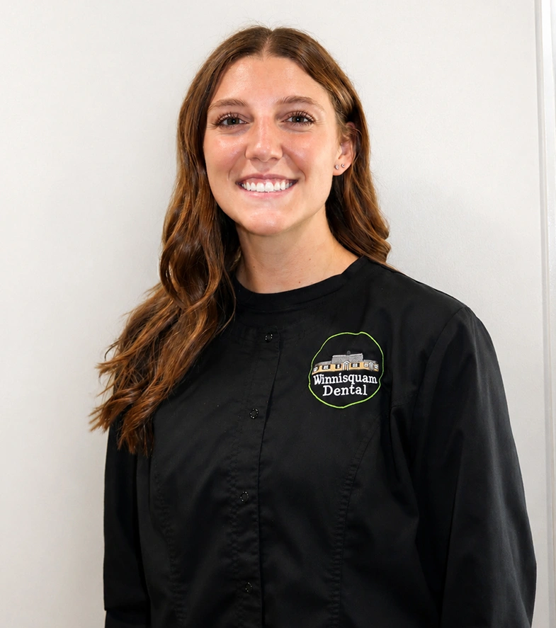 Portrait of Emma, a Winnisquam Dental staff member, smiling in a black scrub jacket